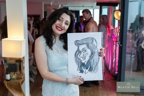 Caricaturist sketching a party guest at a table