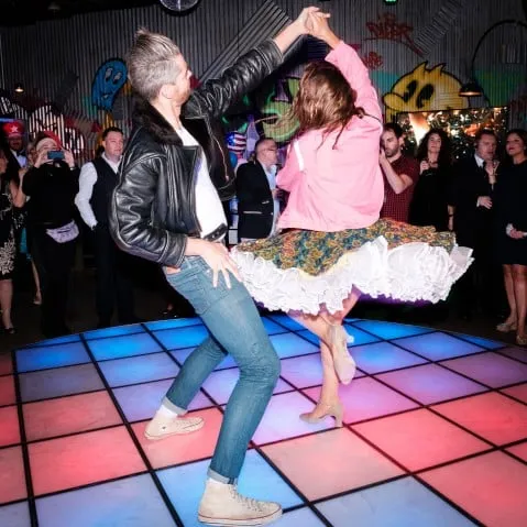 Two dancers in 1950s costume performing a rock and roll jive