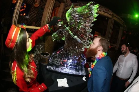 Lit ice luge beside a hostess at a themed awards night