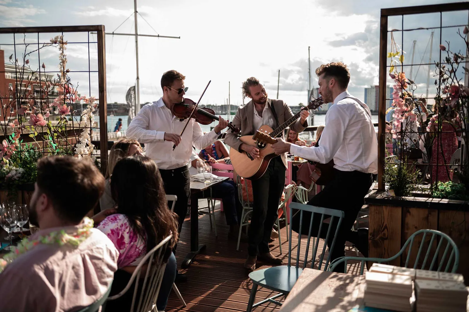 Roaming fiddle trio playing among guests at a company event