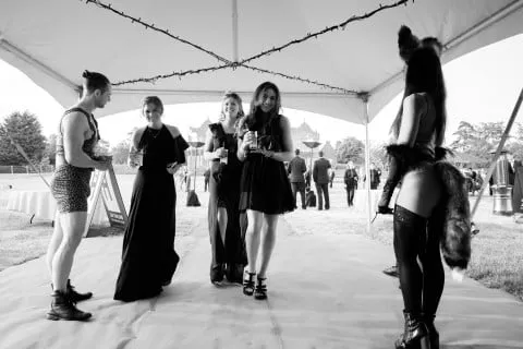 Costumed strongman and fox hostess greeting guests at a summer ball