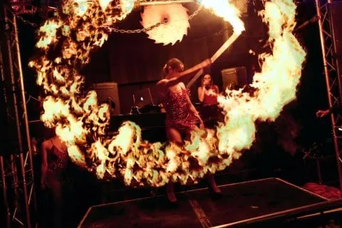 Fire performer sending up a large flame during a Halloween fire show