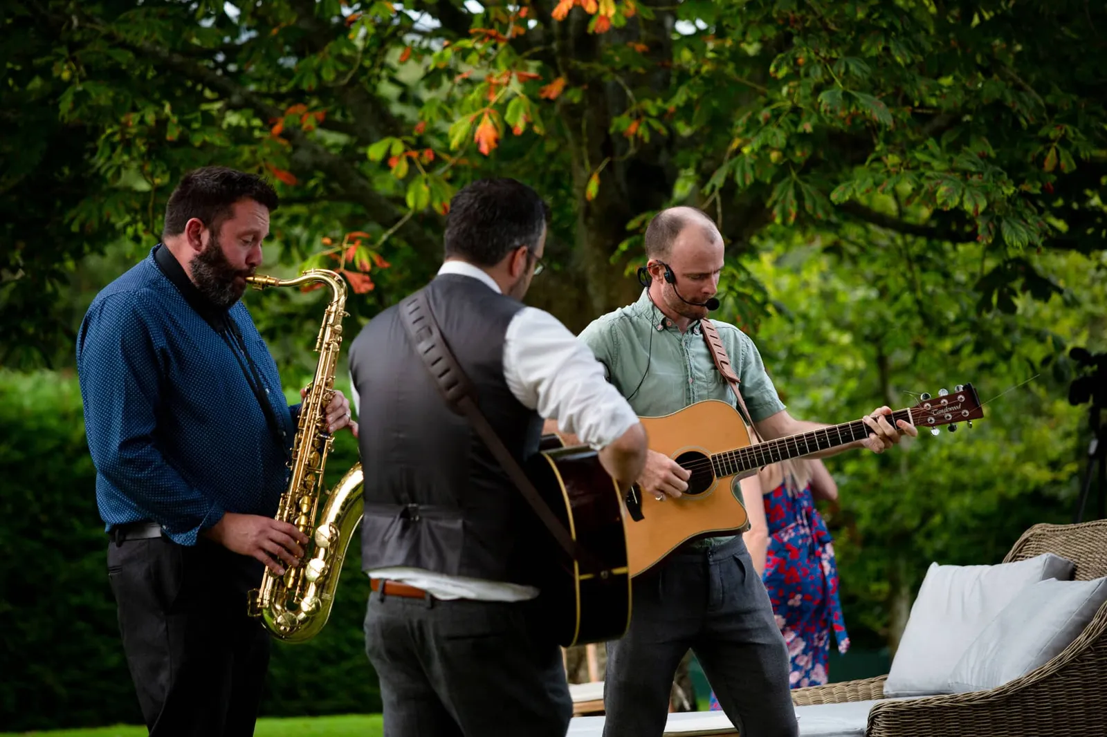 Roving acoustic trio playing at an outdoor summer party