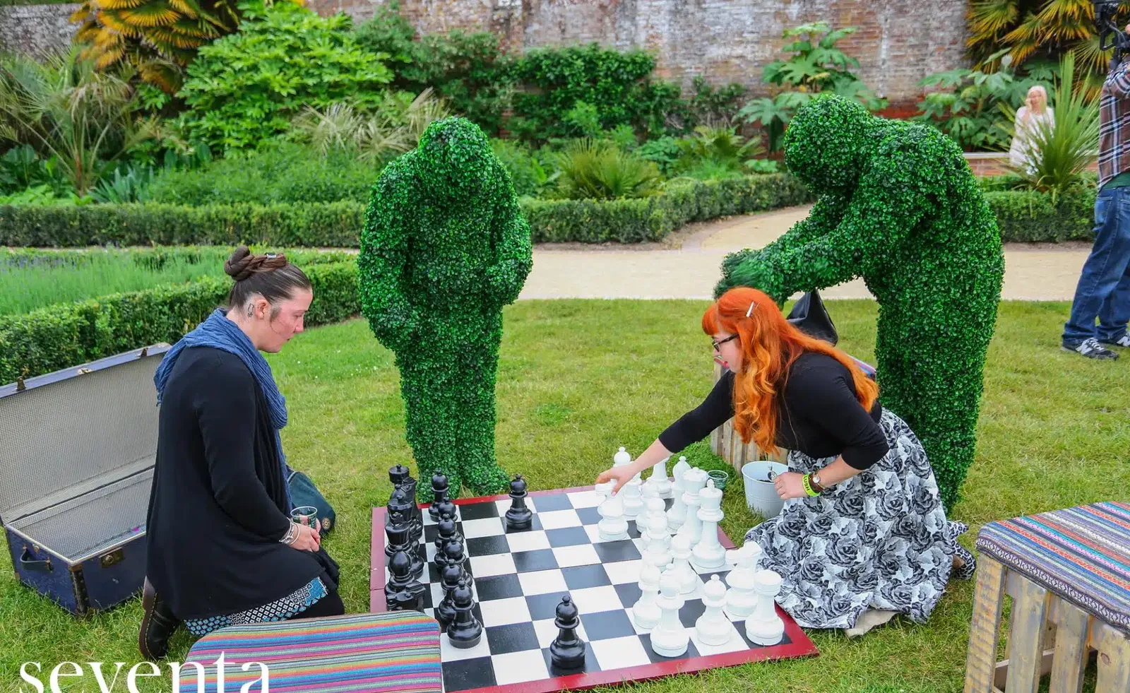Human topiary performer greeting guests in a garden