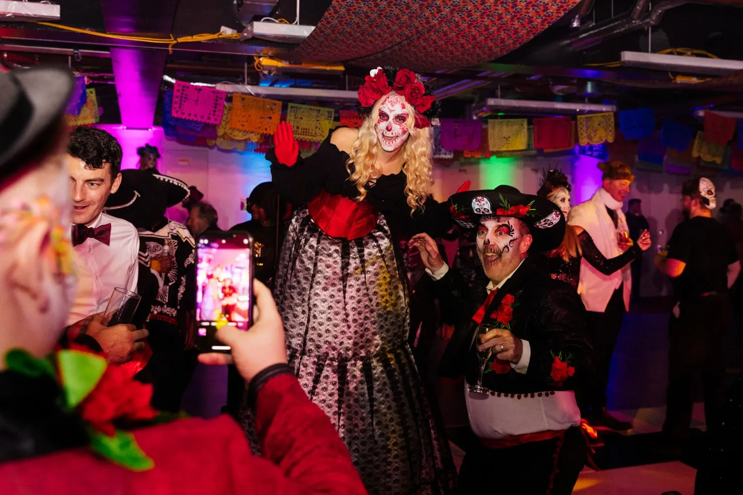 Performers in Day of the Dead costume and face paint at an evening event