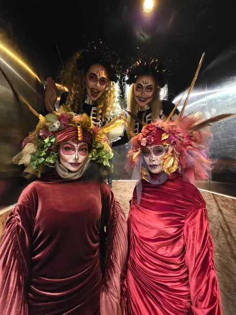 Floral venetians day of the dead with skeleton stilts: living statues
